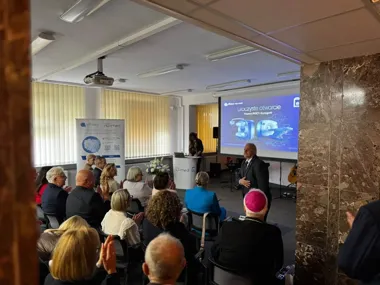 Uroczyste otwarcie pracowni PET/CT i Scyntygrafii w placówce medycznej nu-med, podczas którego mówca w garniturze przemawia do klasyfikującej publiczności.